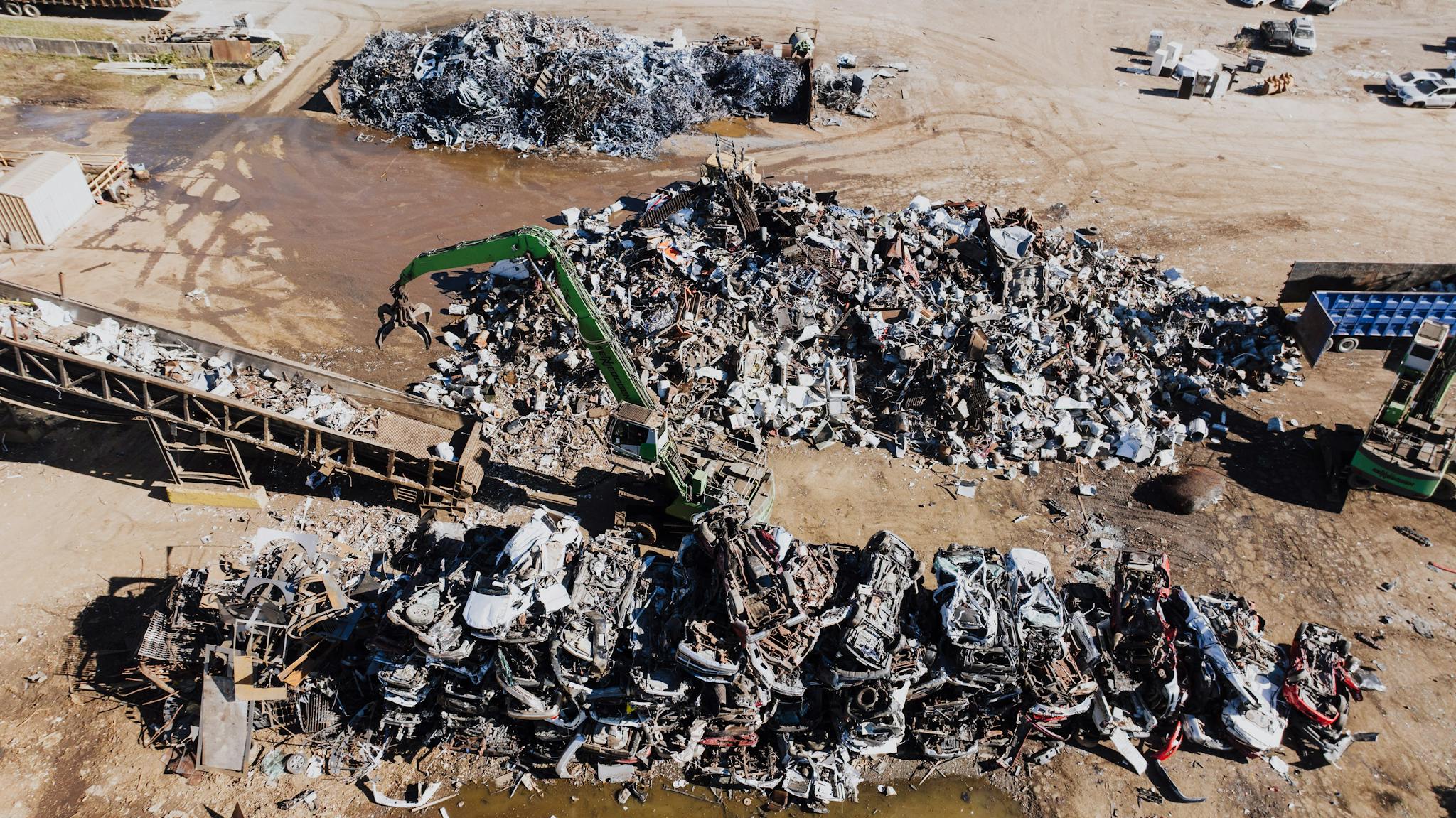Industrial scrapyard with piles of metal and a hydraulic crane in Chattanooga, Tennessee.